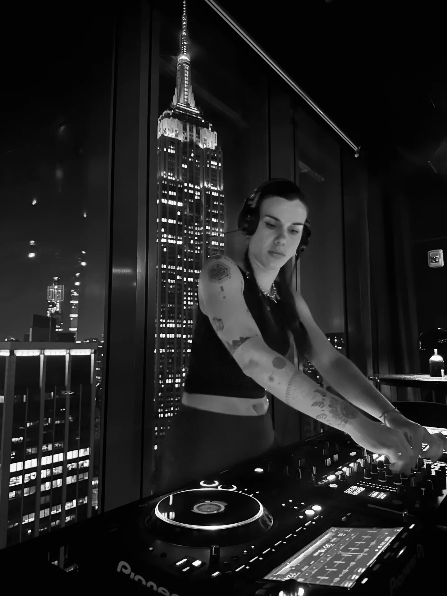 Loreley DJ tocando un set de música electrónica en vivo en Nueva York con el Empire State de fondo — Creadora del programa intensivo para DJs.