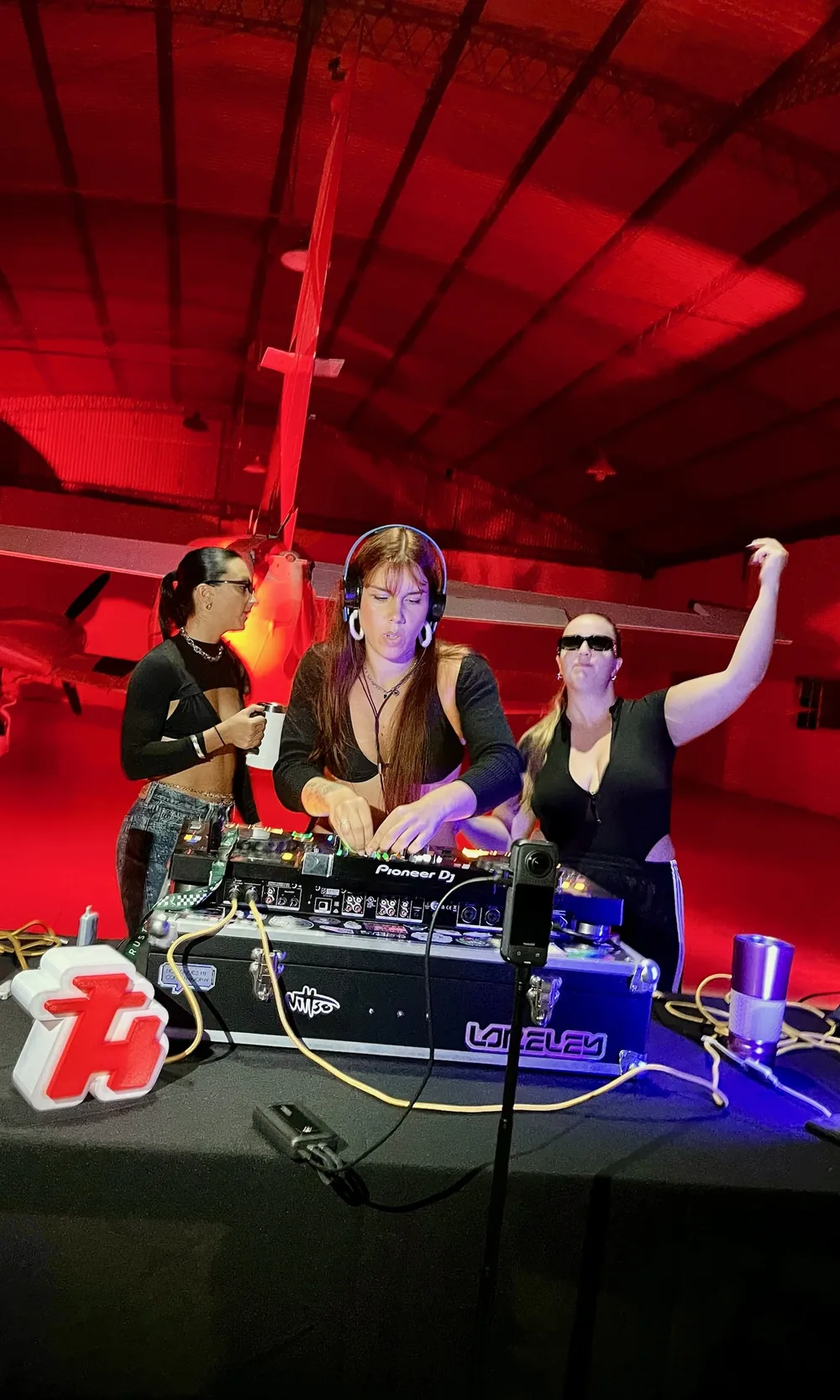 Loreley tocando en una cabina de DJ frente al público en un evento.